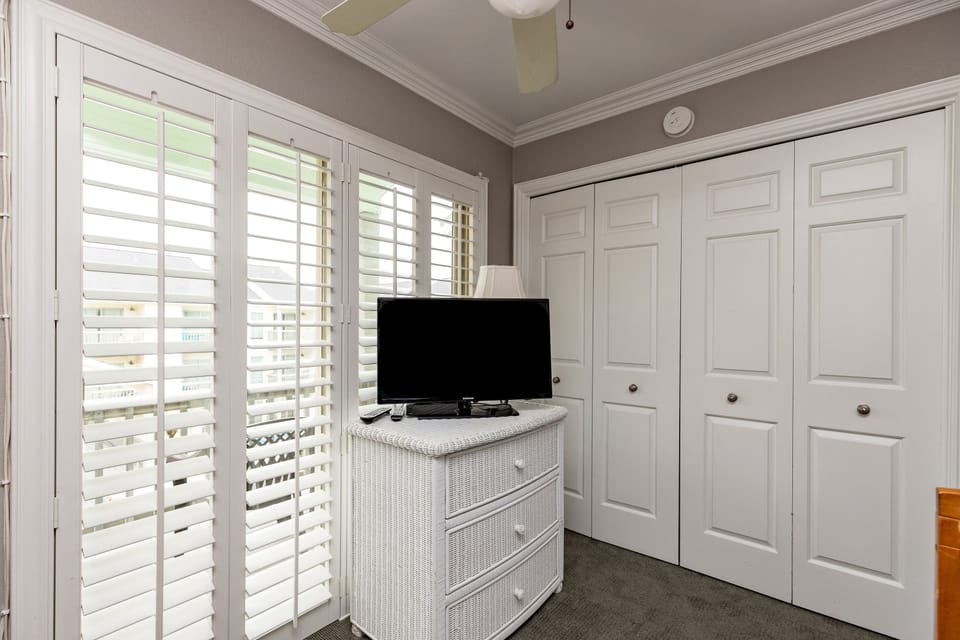 Relax in your bright bedroom with plantation shutters, flat-screen TV, and generous storage space for all your vacation essentials.