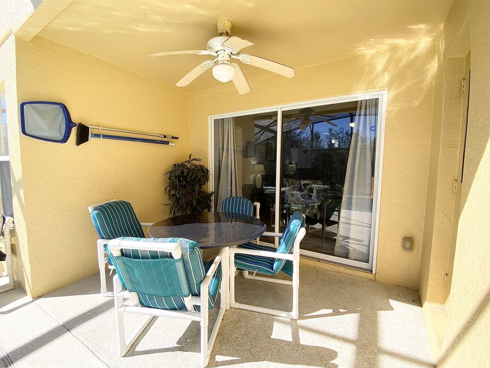 Covered outdoor dining area with a ceiling fan, perfect for al fresco meals and enjoying the fresh air