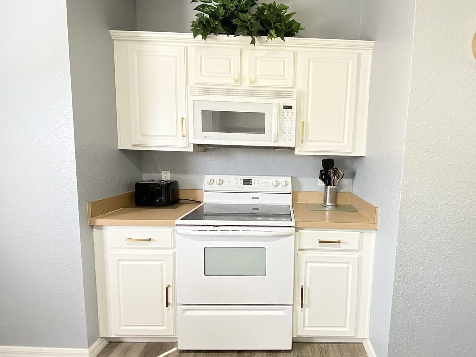 Fully equipped kitchen featuring modern appliances, including a stove and microwave.