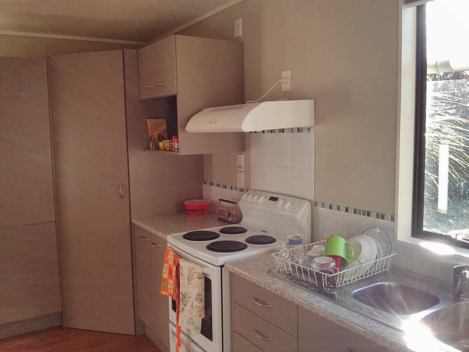 Kitchen equipped with fridge, oven, toaster & coffee percolator. Open plan.