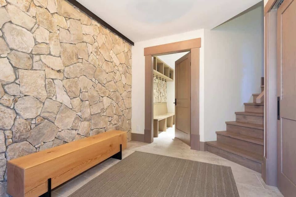 - Spacious entryway with rustic stone walls and warm wood tones  
- Perfect area to store boots and gear after snowy days outdoors  
- Inviting mountain charm welcomes you into the chalet  
