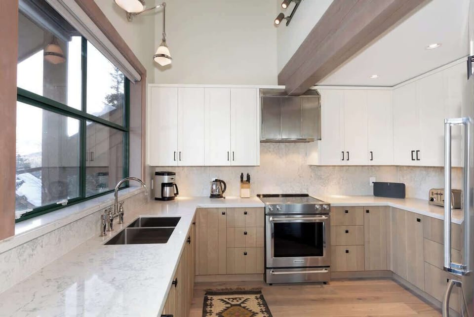 - Bright modern kitchen with sleek marble countertops and wood accents  
- Fully equipped with stainless appliances and scenic window views  
- Perfect for cooking hearty meals after a day on the slopes  
