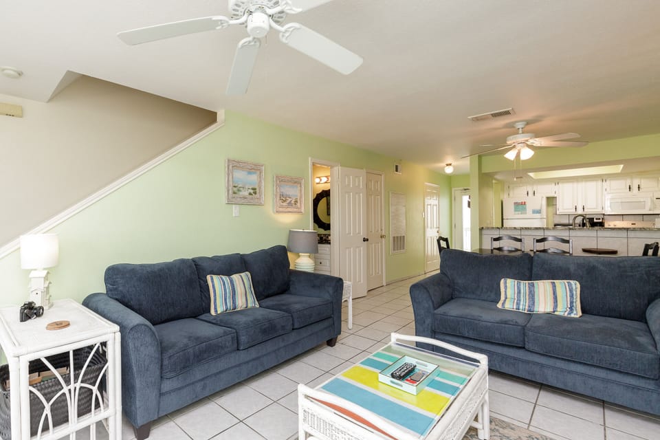 Relax in your bright, airy living space with plush blue sofas and coastal charm—perfect for unwinding after beach days.