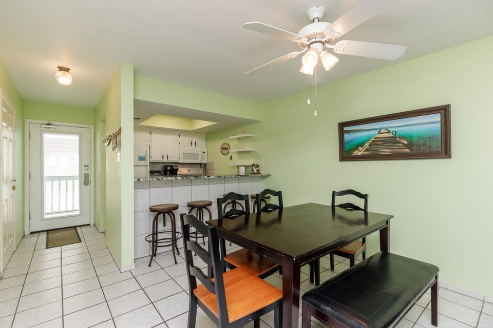 Your bright dining area features a spacious table with seating for six, plus a convenient breakfast bar connecting to your fully equipped kitchen.