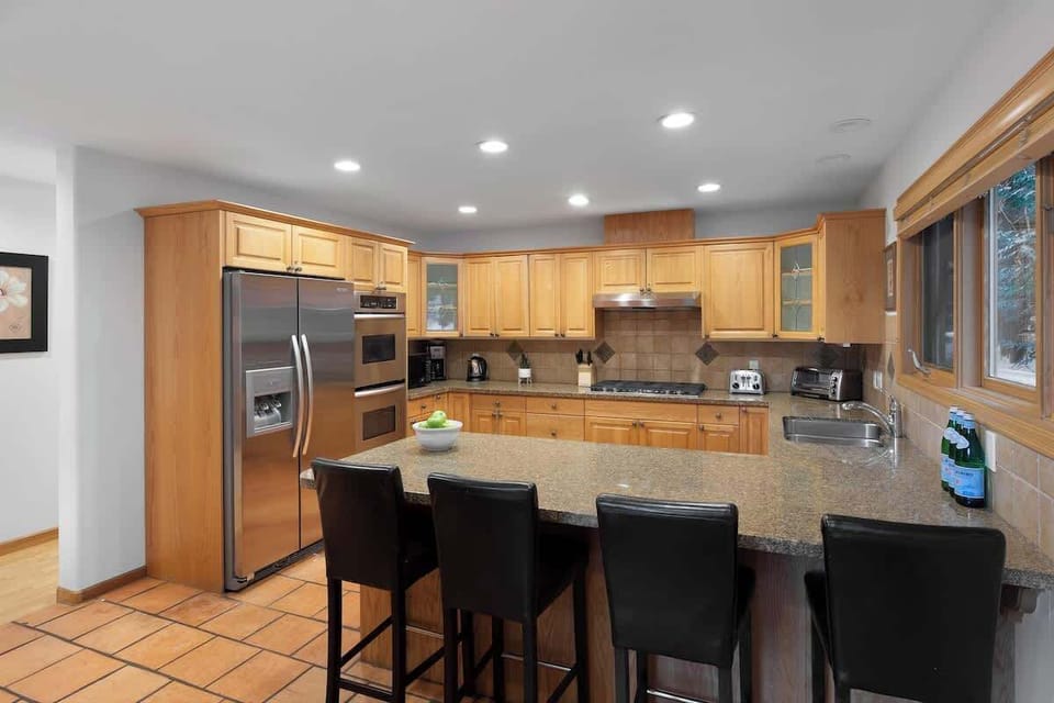 - Modern kitchen with stainless steel appliances and granite countertops for easy cooking  
- Bar seating for four makes it ideal for family breakfasts or evening chats  
- Warm wood cabinetry and forest views bring natural charm to every meal  

