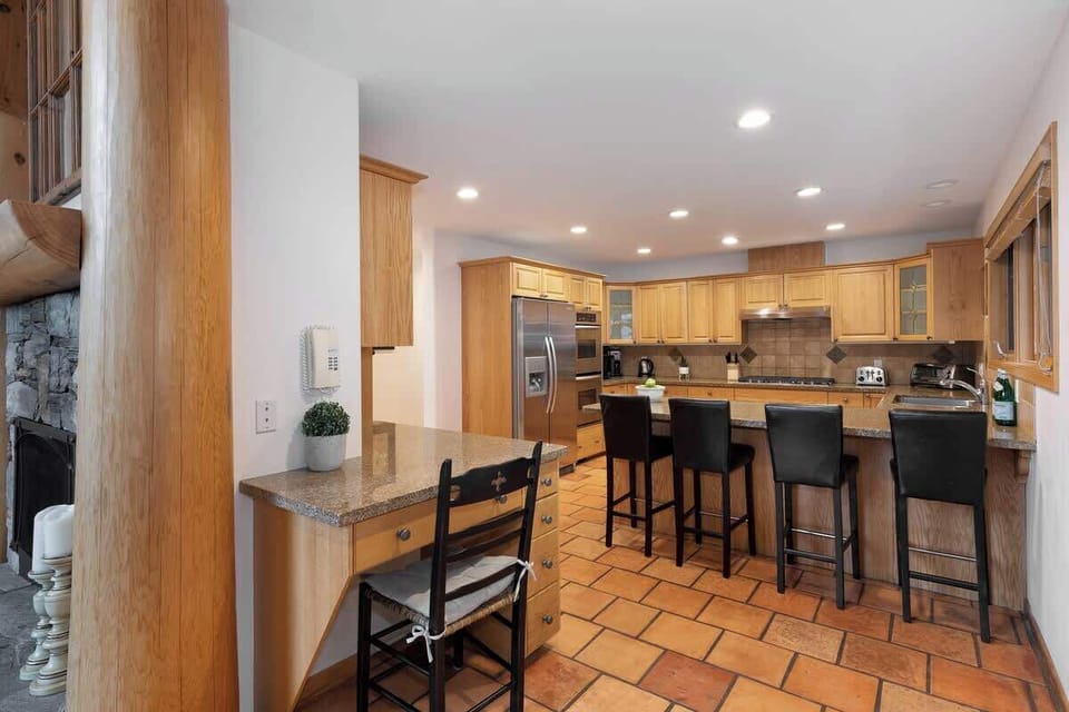 - Open kitchen design with tile floors and bright lighting for group gatherings  
- Spacious island and breakfast bar perfect for casual dining and entertaining  
- Fully equipped setup ensures comfort for extended mountain stays  
