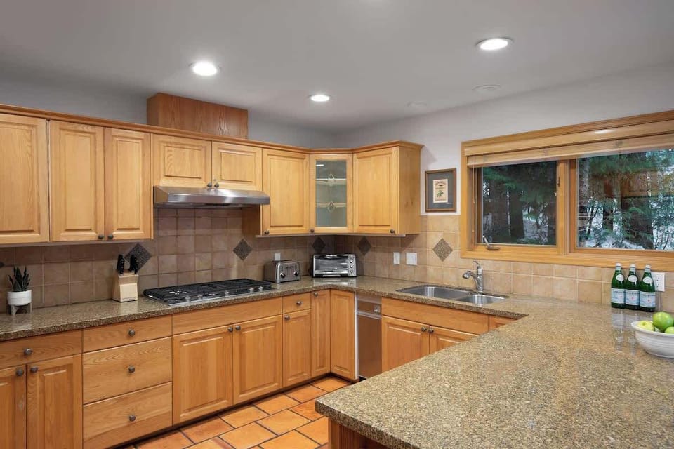 - Spacious kitchen with wood cabinetry and granite countertops for easy meal prep  
- Modern appliances including gas stove, dishwasher, and plenty of counter space  
- Bright window views of the forest make cooking a peaceful mountain experience  