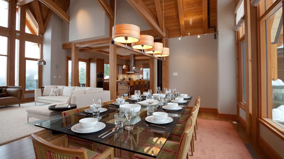 - Dining area blending rustic wood and modern glass table design  
- Large windows frame snow-kissed trees and glowing natural light  
- Ideal for shared meals and laughter in a scenic mountain retreat  
