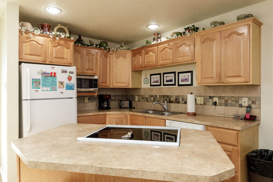 Your fully equipped kitchen awaits with warm wood cabinets, granite counters, and modern appliances for creating memorable meals during your stay.