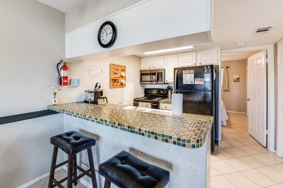 Your spacious kitchen features stylish tile countertops, full appliances, and a convenient breakfast bar where you can start each morning with coffee.