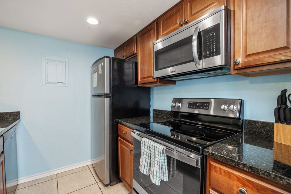 Your fully equipped kitchen awaits with granite countertops, stainless steel appliances, and warm wood cabinets for memorable meal prep.
