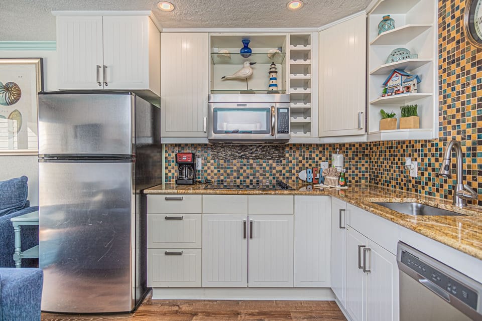 Kitchen is equipped with a fridge/freezer, stove top, microwave, and a dishwasher