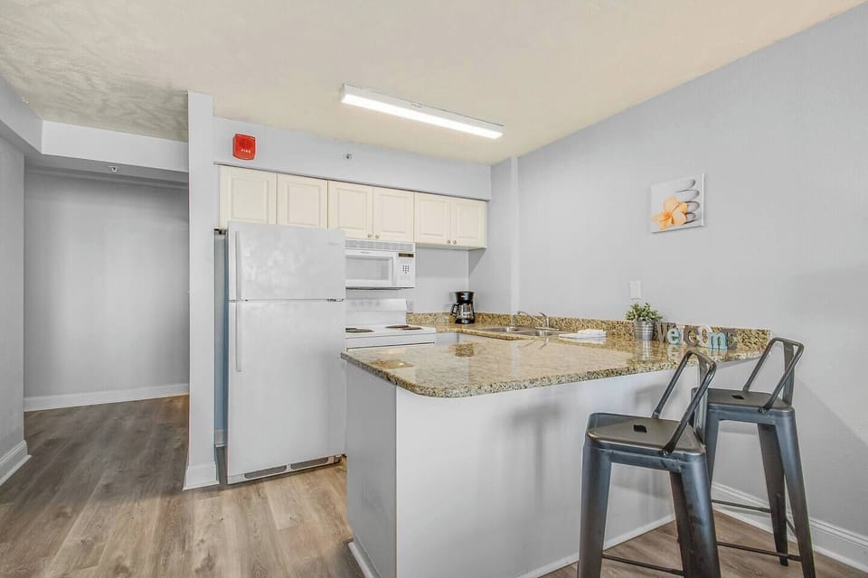 The kitchen area exudes coastal charm, complementing the suite's overall aesthetic for a truly immersive oceanfront living experience.