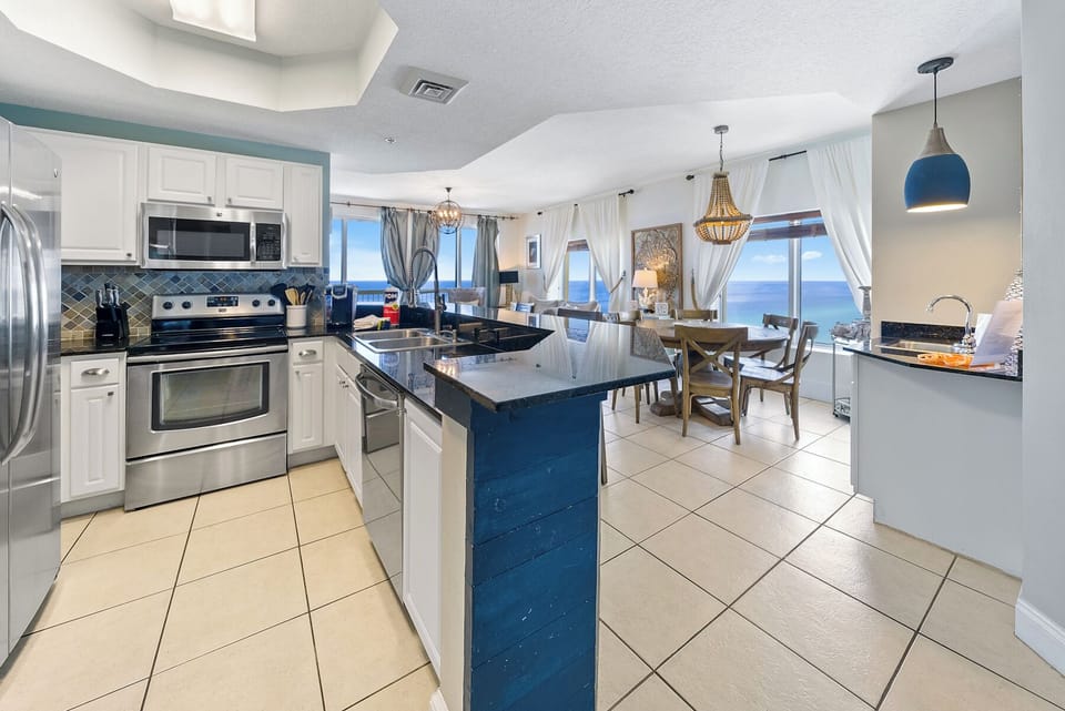 Your fully equipped kitchen flows seamlessly into the dining area, where stunning ocean views create the perfect backdrop for every meal.