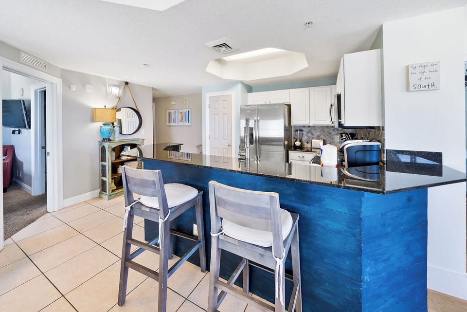 Your modern kitchen features a stunning blue island with granite countertops, perfect for morning coffee or casual meals together.