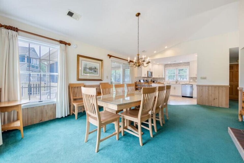Gather around this spacious dining table, perfect for family meals and lively conversations, while natural light pours in through large windows overlooking the neighborhood.