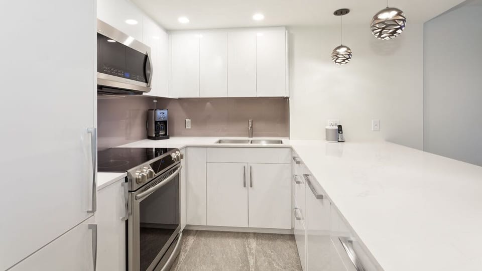 - Modern white kitchen with full appliances and sleek minimalist design  
- Ample counter space and bright lighting for easy meal prep  
- Ideal setup for cooking with family or enjoying après-ski snacks  