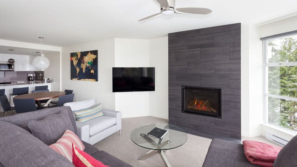 - Contemporary living space featuring stone fireplace and scenic views  
- Cozy sectional perfect for relaxing after mountain adventures  
- Modern décor combines warmth comfort and mountain elegance  
