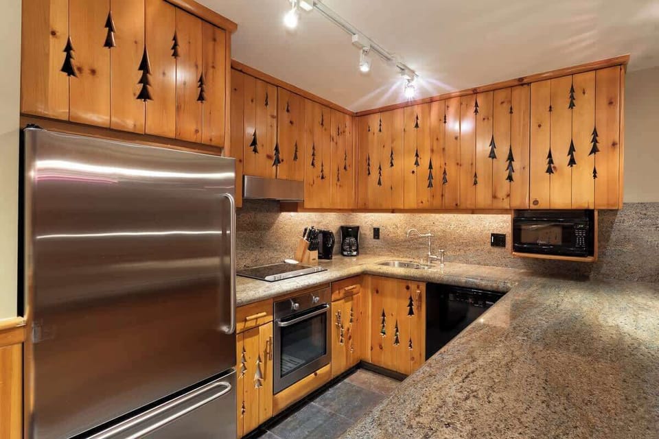 - Rustic pine kitchen with stainless steel appliances and granite counters  
- Whistler-inspired decor with tree-carved cabinets and warm tones  
- Perfect for cooking hearty mountain meals after a day on the slopes  
