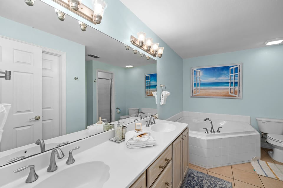 Ensuite bathroom with dual vanities, a jetted soaking tub, and walk-in shower.