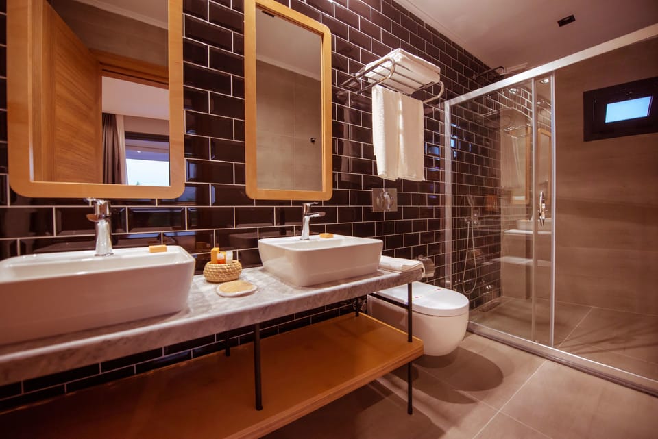 Deluxe Room, Jetted Tub, Pool View | Bathroom amenities | Shower, hydromassage showerhead, designer toiletries, hair dryer