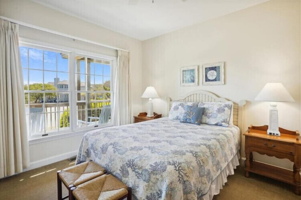 Relax in your bright, coastal-themed bedroom with water views and soft natural light. Wake to peaceful scenery framed by large windows and drift to sleep surrounded by beach-inspired touches.