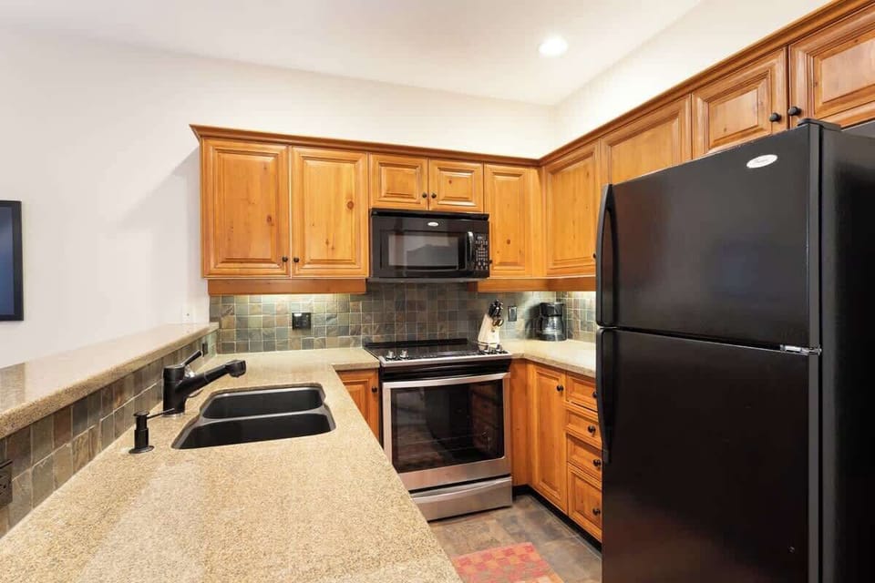 - Fully equipped kitchen with black appliances and wooden cabinetry  
- Perfect for cooking meals with modern convenience and rustic charm  
- Great for families and groups seeking a comfortable mountain stay  
