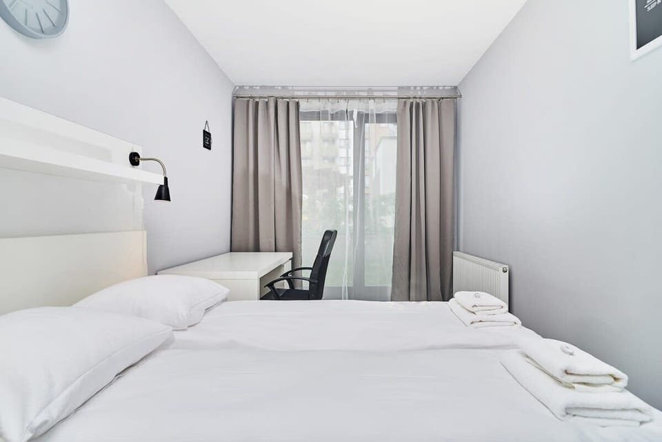 Bedroom of Świstackiego 19/10 with double bed, desk, chair, night lamps and wardrobe