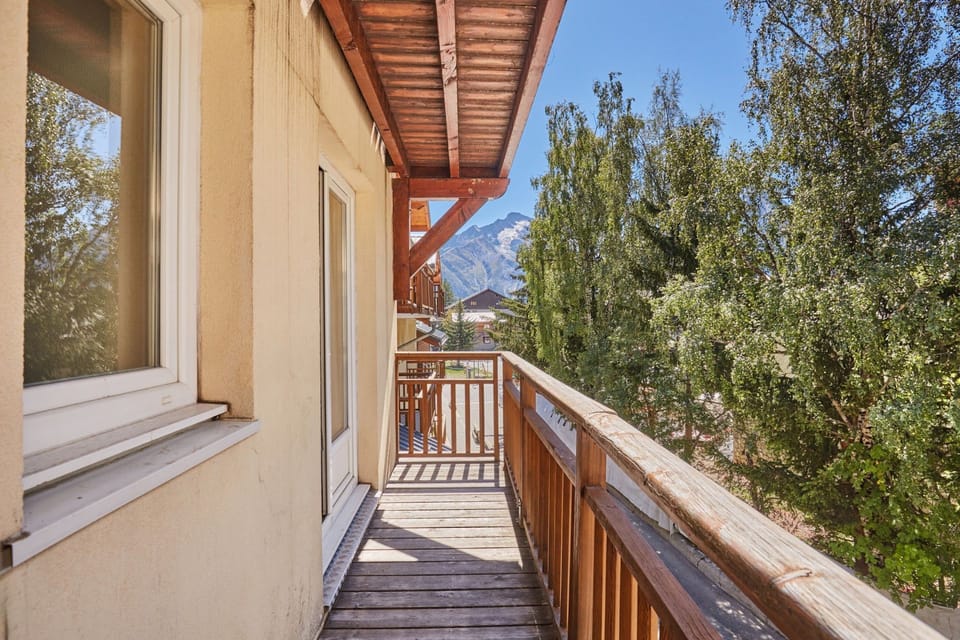 Balcony view over trees towards a mountain