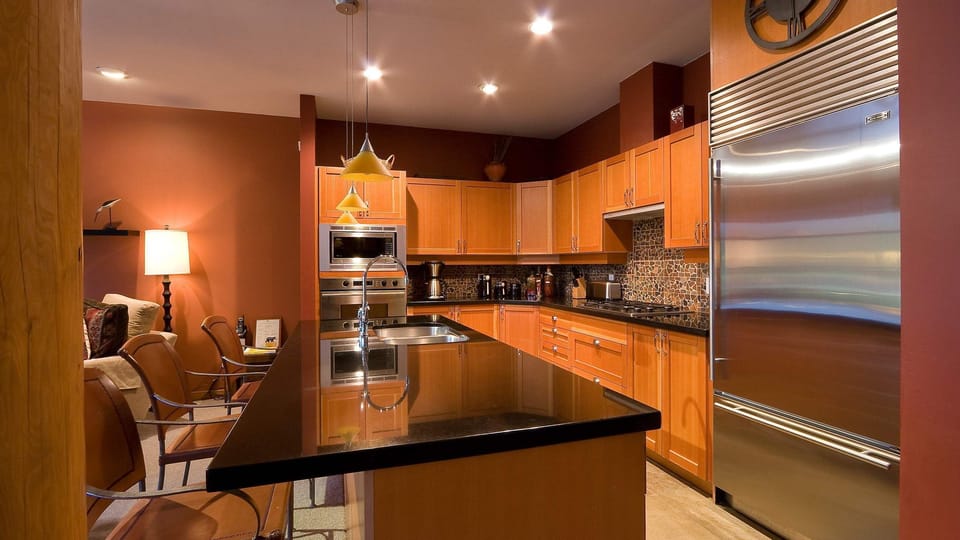 - Sleek kitchen with granite counters and wood cabinetry  
- Stainless steel appliances and warm recessed lighting  
- Fully equipped space for home-style mountain meals  