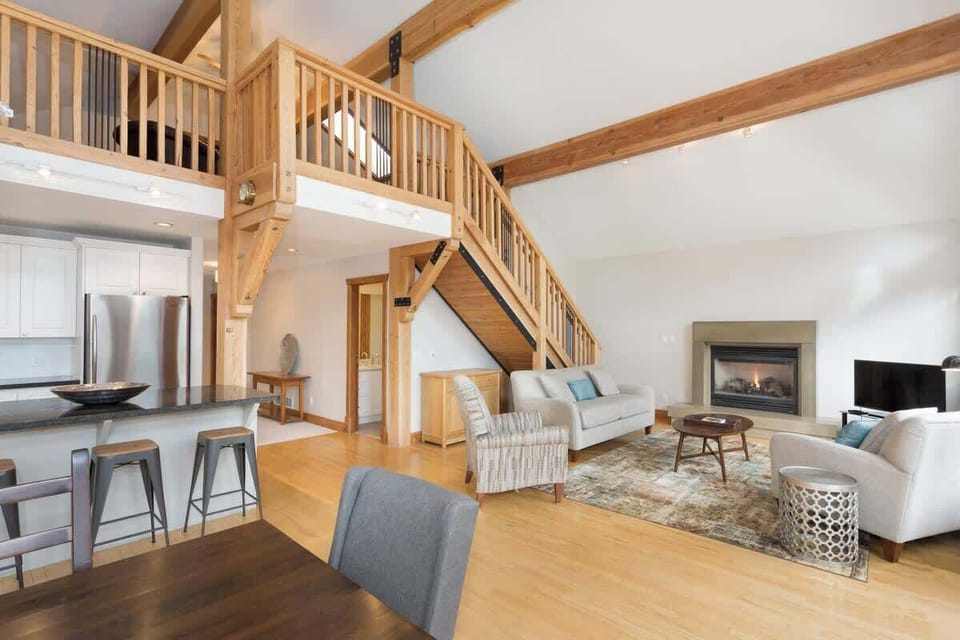 - Spacious living room with high ceilings and rustic timber beams  
- Cozy fireplace centerpiece perfect for gatherings and relaxation  
- Open concept layout blends dining and lounge beautifully  