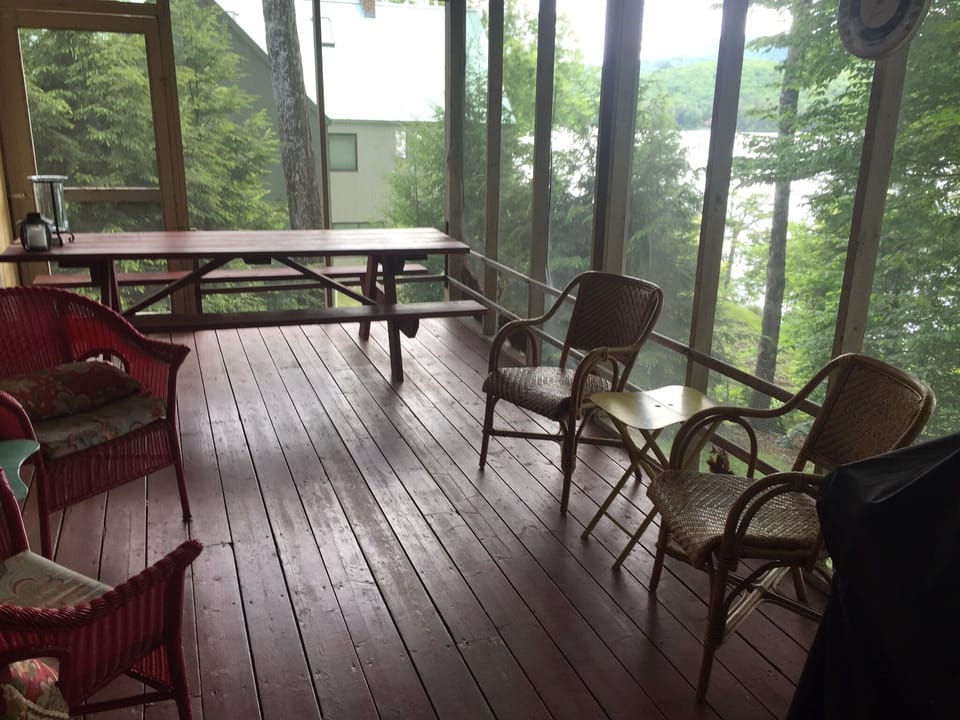Screened in porch overlooking lake with picnic table that seats 10.