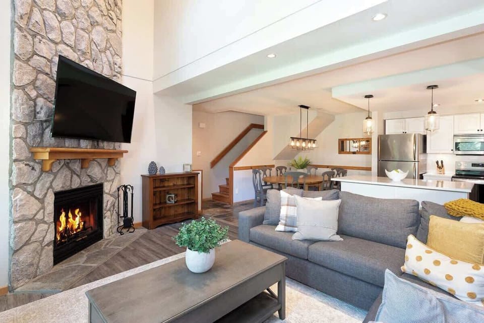 - Cozy lounge with stone fireplace and soft modern décor  
- Spacious layout connects to dining and full kitchen area  
- Ideal for unwinding after mountain hikes or snowy days  