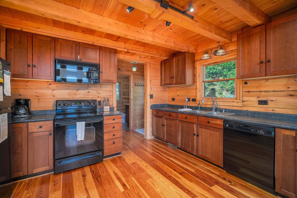 Kitchen with smooth surface stove, dishwasher, and standard coffee maker.
