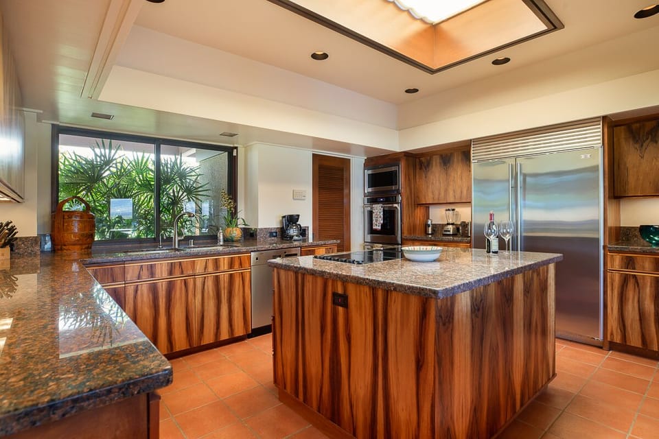 Gourmet kitchen with rich wood cabinetry, top-tier appliances, and ample counter space.