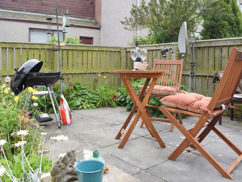 Paved patio area with outdoor furniture and BBQ | Horseshoe Cottage, Freuchie, near Cupar