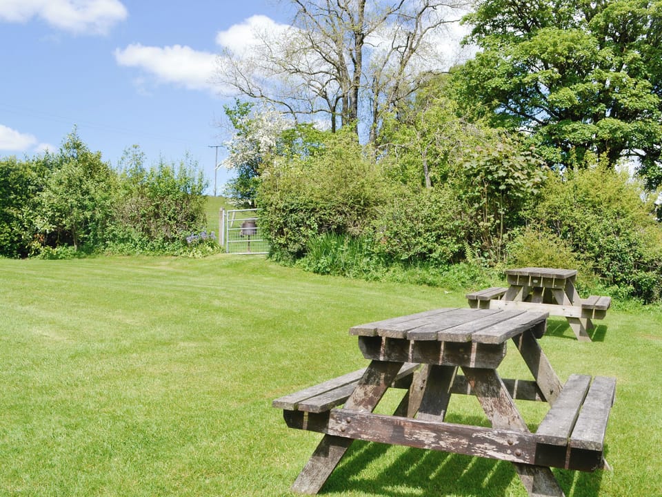 Enclosed garden area with outdoor seating | Woodland View - Cefncoedbach Farm, Sarnau, near Brecon
