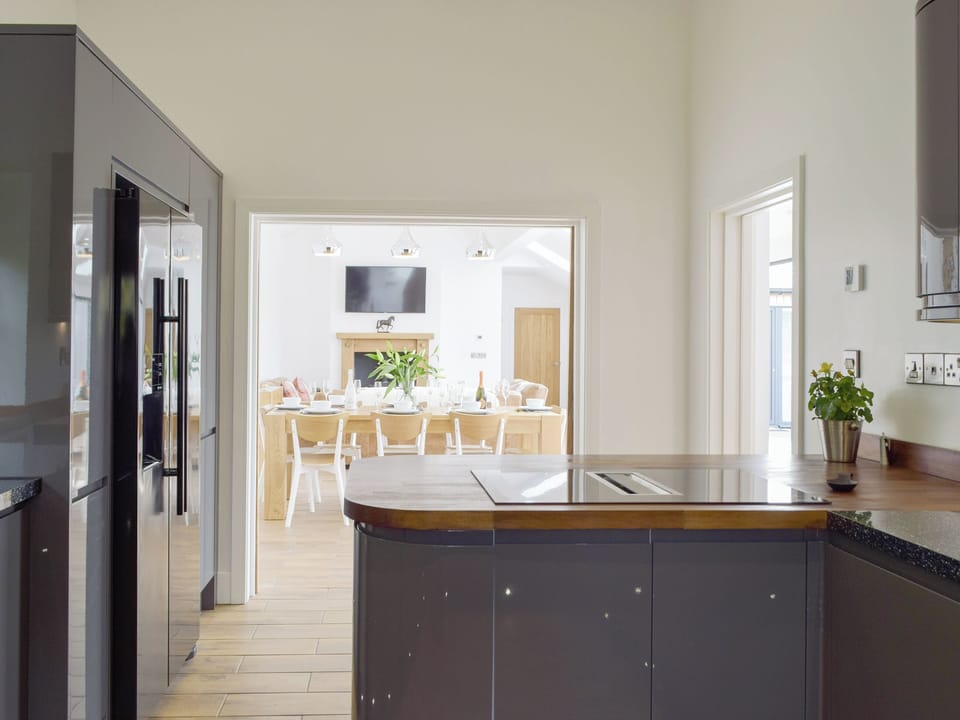 Spacious kitchen with open-aspect pocket doors to living areas | Manor Lodge Stables, Wiston, near Haverfordwest