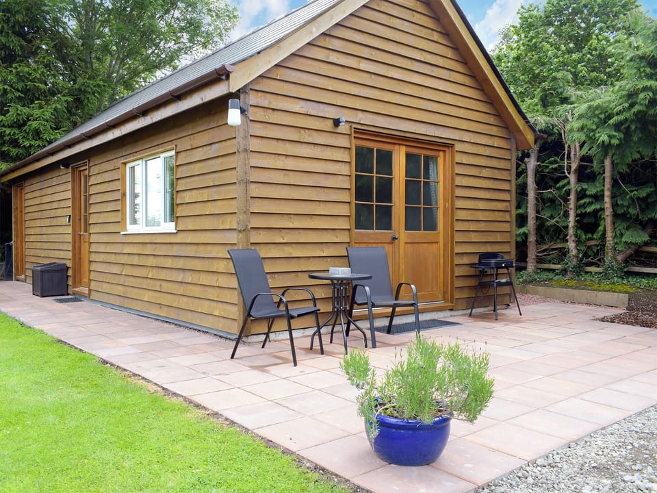 Patio with garden furniture and barbecue | Walkers Lodge, Dormington, near Hereford