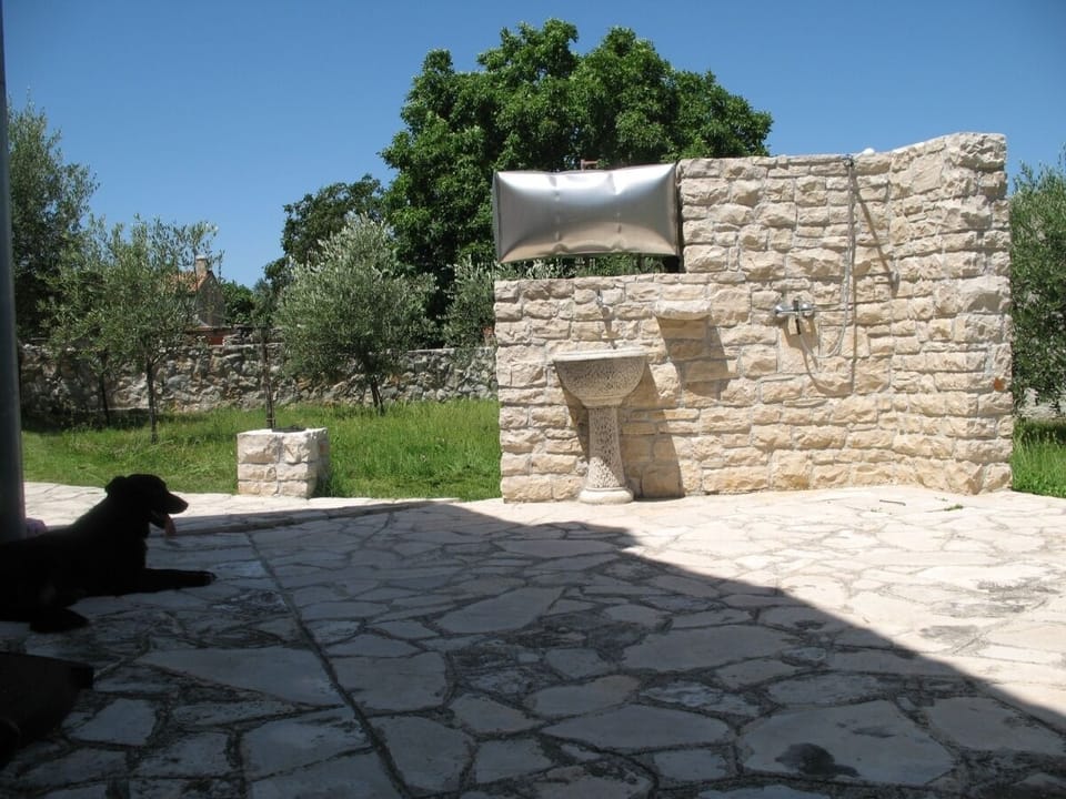 External stone shower and olive garden