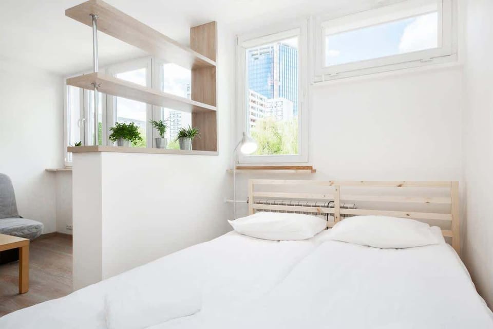 Another angle of the main living area with the bed, sofa, and dining table all visible, maximizing the studio’s space.