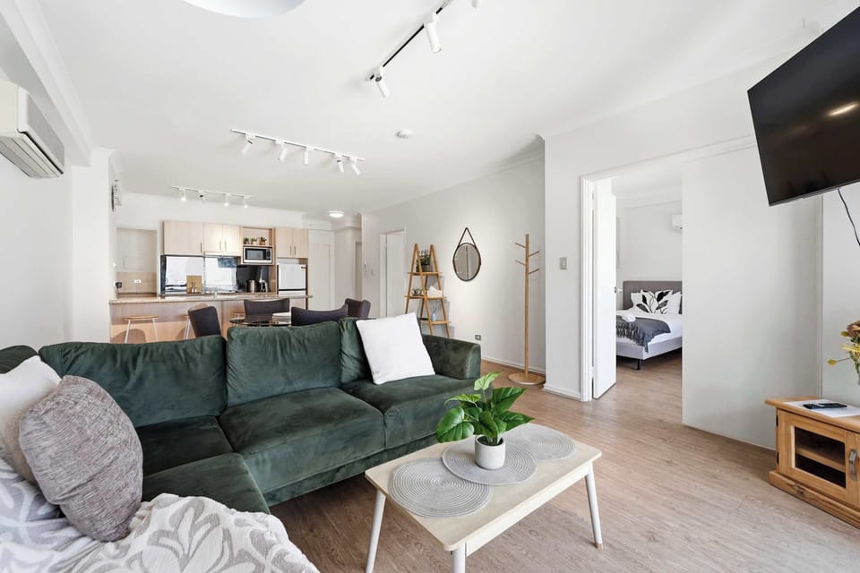 Designed for comfort and convenience, this modern living area offers a plush lounge, Smart TV, air conditioning, a fully equipped kitchen, dining table, coffee station, and thoughtful décor for a relaxing stay.