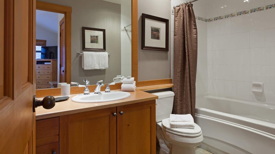 - Bathroom with bathtub and wooden vanity for a cozy touch  
- Bright and clean layout featuring modern fixtures  
- Perfect for refreshing after a day of skiing or hiking  
