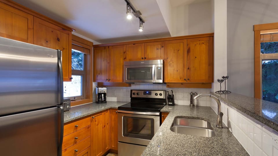 - Kitchen with stainless steel appliances and rich wood cabinetry  
- Granite counters and full amenities for home-style cooking  
- Perfect for preparing warm meals after a day in the snow  
