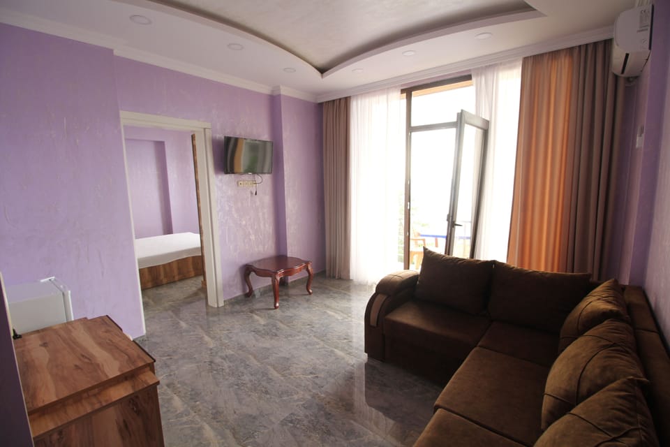 Deluxe Quadruple Room | Living area | Plasma TV, fireplace