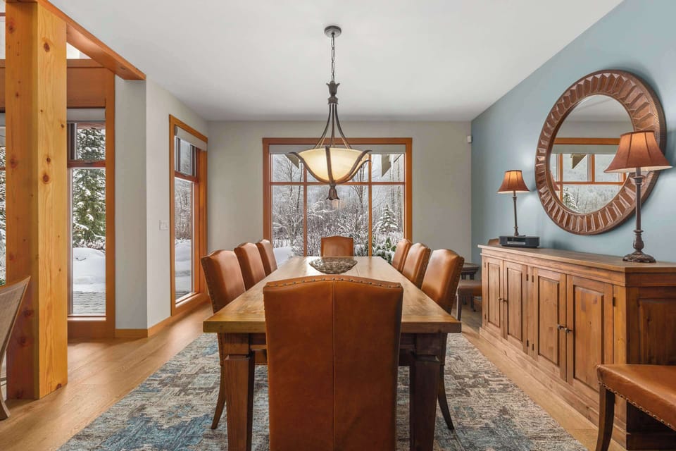 - Elegant dining area with wooden table seating eight under warm lighting  
- Large window view and decorative mirror create a bright inviting feel  
- Ideal space for family dinners or group meals after a day outdoors  

