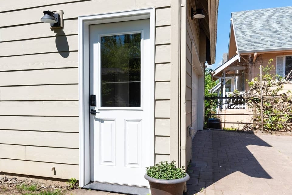 Lighted driveway leads to entrance door with keyless deadbolt lock.