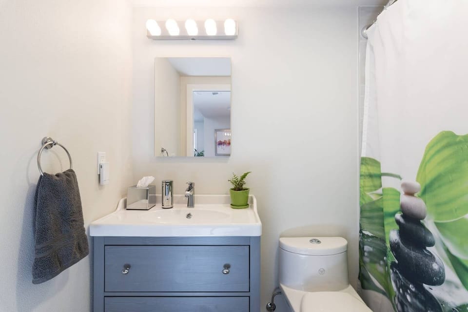 Bathroom stocked with a hair dryer, curling iron & automatic hand soap dispenser