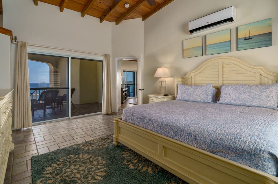 The main level`s primary bedroom with king bed, private balcony, AC, flat screen TV, ensuite bath, and AC.