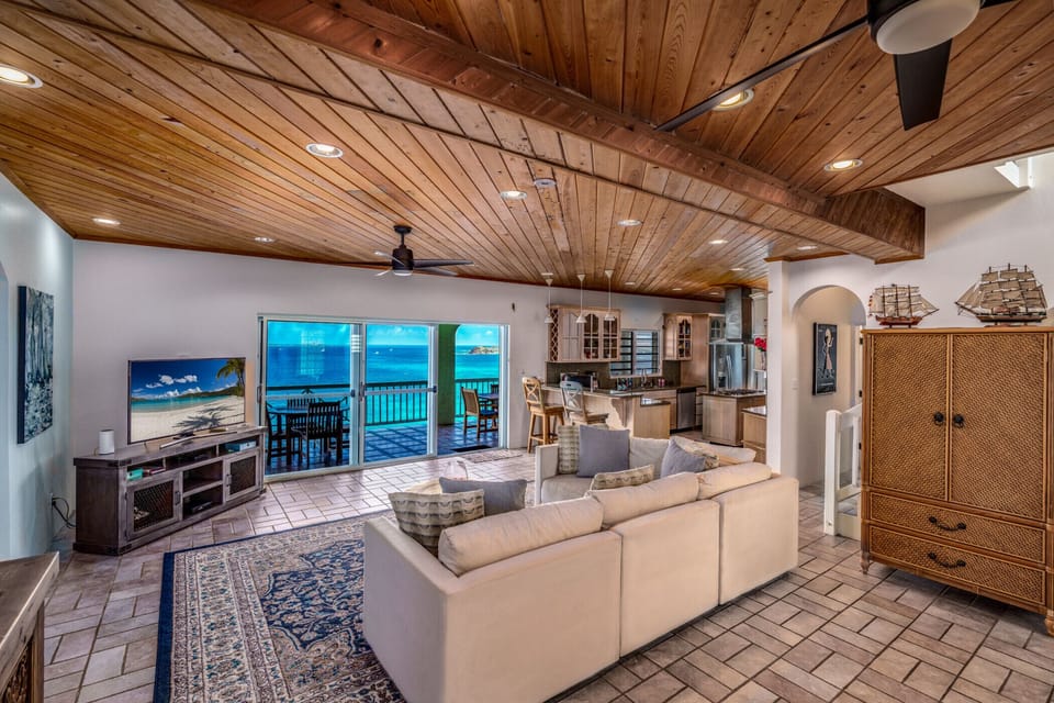 The spacious living room with AC, flat screen TV, and balcony access.